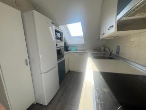 a kitchen with white cabinets and a sink and a window at La Perla del Pirineo in Jaca +6 photos
