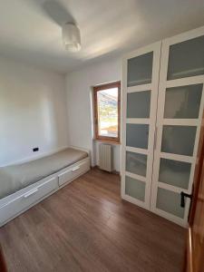 ein leeres Zimmer mit einem Bett und einem Fenster in der Unterkunft Casa dello sport in Roccaraso