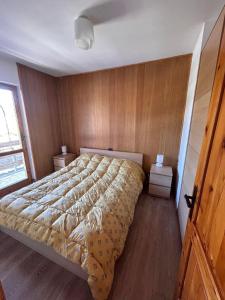 Schlafzimmer mit einem großen Bett und Holzwänden in der Unterkunft Casa dello sport in Roccaraso
