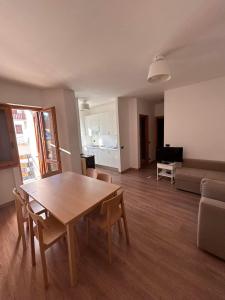 ein Wohnzimmer mit einem Holztisch und einem Sofa in der Unterkunft Casa dello sport in Roccaraso
