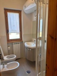 ein Bad mit einem WC, einem Waschbecken und einem Fenster in der Unterkunft Casa dello sport in Roccaraso