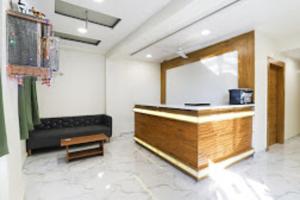 a room with a reception desk and a couch at Hotel Sunrise Inn in Ahmedabad