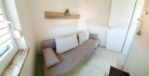 a couch with two pillows sitting in a room at Apartments Villa Ines Skofije -near Koper in Zgornje Škofije
