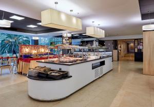 a restaurant with a counter with food on it at Hotel Surf Mar in Lloret de Mar