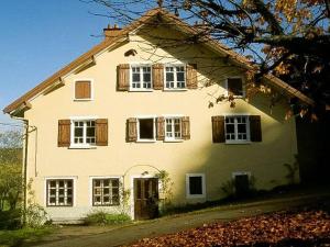 a large white house with wooden shuttered windows at Chalet Cosy Lisière de Forêt in Xonrupt-Longemer