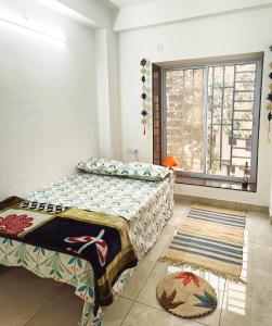 a bedroom with a bed and a window at Traveller's Nest in Siliguri