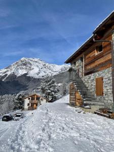 a log cabin in the snow with a mountain at Baita Chalet La Masun in Chiesa in Valmalenco
