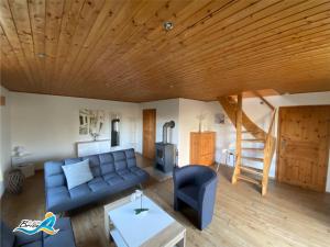 sala de estar con sofá azul y techo de madera en Ferienhaus-zur-leichten-Brise, en Boiensdorf
