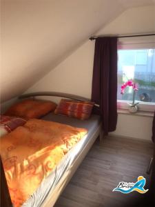 1 dormitorio con 1 cama y ventana en una habitación en Ferienhaus-zur-leichten-Brise en Boiensdorf