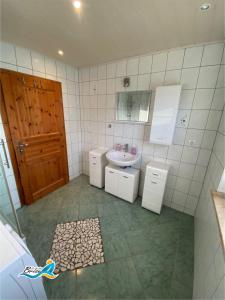 Baño pequeño con lavabo y espejo en Ferienhaus-zur-leichten-Brise, en Boiensdorf