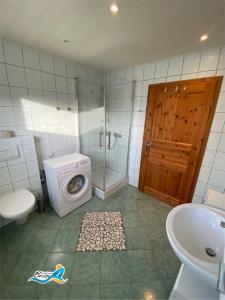 y baño con lavamanos y lavadora. en Ferienhaus-zur-leichten-Brise, en Boiensdorf