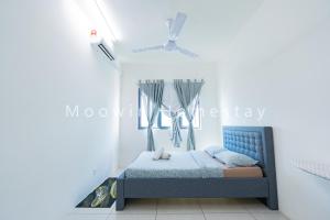 a bedroom with a blue bed in a white wall at Cozy&Comfy Suite Room Perai in Perai