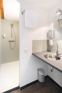 a bathroom with a sink and a shower at Hotel Blooker in Renesse