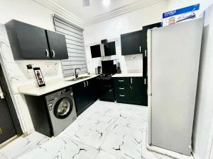a kitchen with black and white marble flooring and a washer at Kemc Apartment in Ashalebotwe