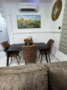 a dining room with a black table and chairs at Kemc Apartment in Ashalebotwe +3 photos