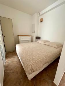 une petite chambre avec un lit et une commode dans l'établissement Appartement l'Arancetu vue mer avec piscine, à Biguglia