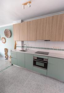 a kitchen with white and wooden cabinets and a sink at Las Flores Apartments in Nerja +10 photos