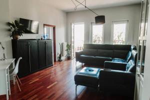 uma sala de estar com um sofá preto e uma mesa em Apartament Planty 16C em Kielce