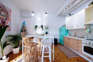 a kitchen with white cabinets and a blue refrigerator at Piraeus Urban Gem in Piraeus
