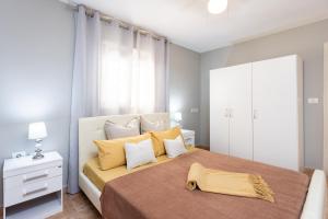 1 dormitorio con 1 cama grande con almohadas amarillas en Villa lussuosa a 1,5 chilometri da Costa Adeje, en Adeje