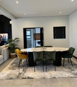 a living room with a table and chairs at Phoenix Home in Cape Town