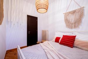 a bedroom with a white bed with red pillows at Piraeus Urban Gem in Piraeus
