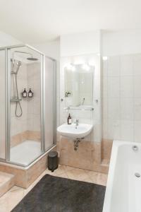 a bathroom with a shower and a sink and a tub at Ferienwohnung "Charlotte" nahe der Elbe mit kostenlosem Parkplatz vor der Tür in Magdeburg
