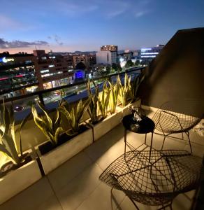 balcón con 2 sillas y vistas a la ciudad en Luxury Loft in Bogota with Private Terrace and Jacuzzi, en Bogotá