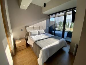 a bedroom with a bed and a large window at Luxury Loft in Bogota with Private Terrace and Jacuzzi in Bogotá
