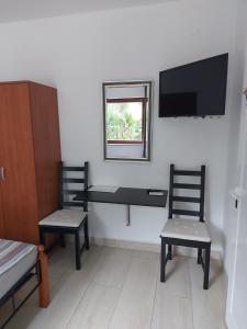 a room with two chairs and a tv on the wall at Ferienhaus Bozena Appartment 3 in Vrsar