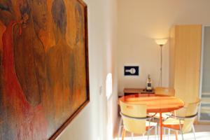 a dining room with a table and a painting at Appartamento Levante in Bologna