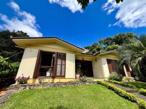 本图贡萨尔维斯Casa da Nona - Vale dos Vinhedos的前面有草坪的小黄房子