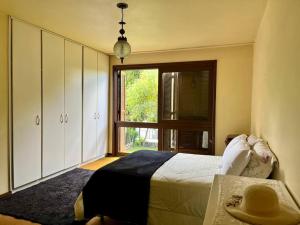 本图贡萨尔维斯Casa da Nona - Vale dos Vinhedos的一间带床、窗户和桌子的卧室