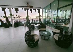 a lobby with chairs and tables in a building at Cozy&Comfy Suite Room Perai in Perai
