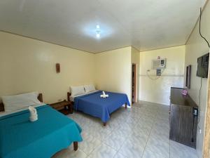 a hotel room with two beds and a television at Dancalan Beach Resort in Donsol