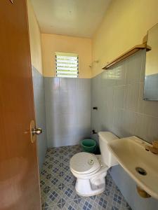 a bathroom with a toilet and a sink at Dancalan Beach Resort in Donsol
