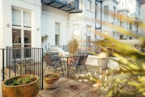 a patio with a table and chairs and buildings at Gresham House in Eastbourne