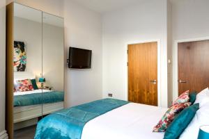 a bedroom with a bed and a mirror at Gresham House in Eastbourne