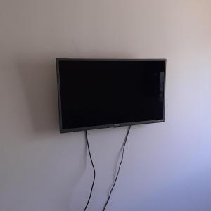 a flat screen tv hanging on a white wall at Canto do sabiá in Rio de Janeiro