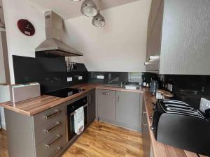 a kitchen with a stove and a counter top at One Bedroom Apartment - Carbost - Skye in Carbost