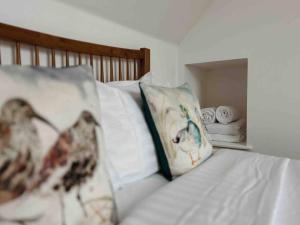 uma cama com uma almofada e toalhas em One Bedroom Apartment - Carbost - Skye em Carbost