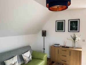 a living room with a green couch and a table at One Bedroom Apartment - Carbost - Skye in Carbost