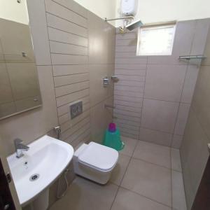 La salle de bains blanche est pourvue d'un lavabo et de toilettes. dans l'établissement Casa Pearl, à Ernakulam