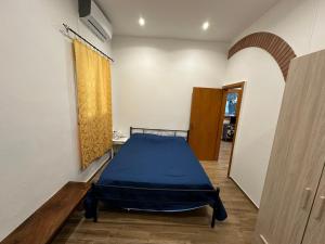 um quarto com uma cama azul num quarto em House Cefalù 1915 em Lascari