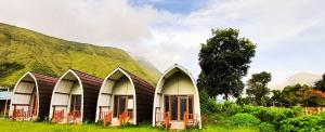 un grupo de tres casas frente a una montaña en Tangga Bungalows en Sembalunlawang