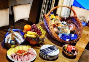 una mesa con una cesta de fruta y platos de comida en Chalets Jasná Collection Záhradky en Demanovska Dolina