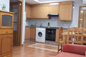 a kitchen with a washing machine and a table at Acogedor apartamento en la playa de Canet in Canet de Berenguer