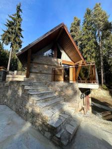 a house with a stone wall and some stairs at CHALET ELEVEN in Dospat