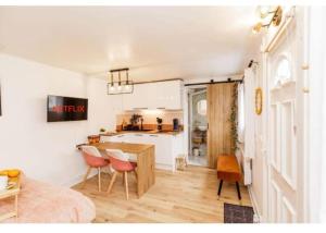 - une cuisine et une salle à manger avec une table et des chaises dans l'établissement Charmant studio lumineux calme, à Asnières-sur-Seine