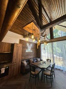 uma sala de jantar com uma mesa e um sofá em CHALET ELEVEN em Dospat